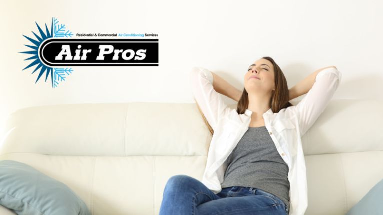 A woman relaxes on a white couch with her hands behind her head, enjoying comfortable air. The "Air Pros" air conditioning services logo appears in the top left corner—perfect comfort for any Spokane home.