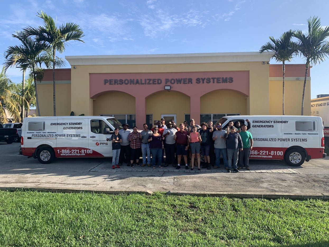 A group of people stands in front of a building labeled "Personalized Power Systems," with two Air Pros USA vans parked on either side, highlighting their expertise in air conditioning and HVAC services.
